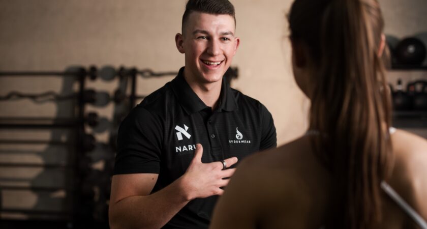 A photo of Tristan from Naru Fitness providing personal training advice to a client.