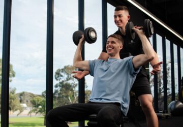 Photo of Tristan from Naru Fitness helping a client at a gym.