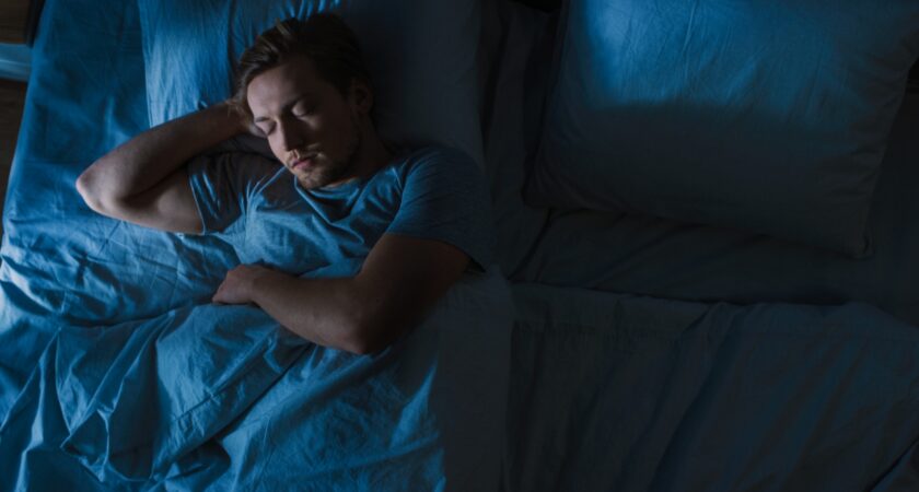 Photo of a man asleep in bed.